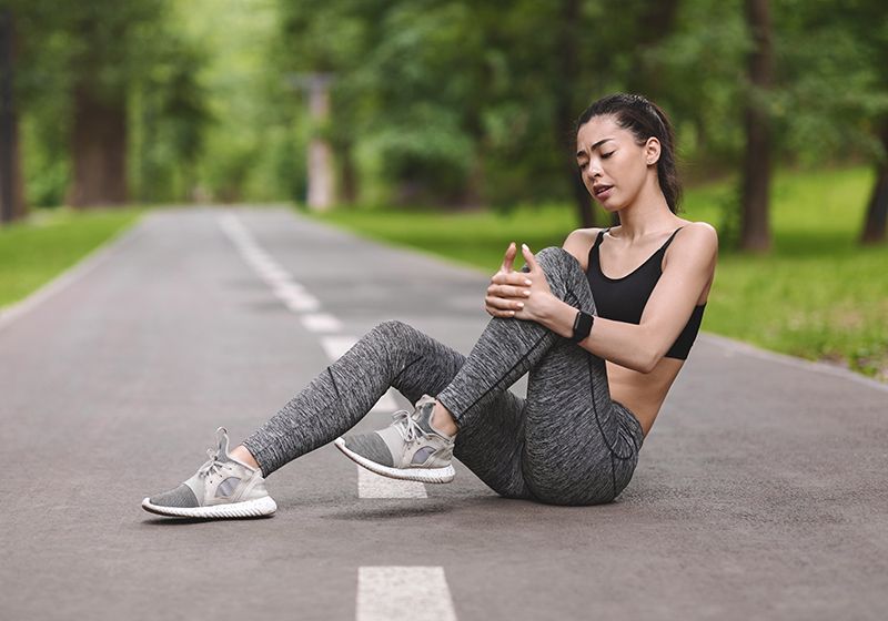 Una deportista sentada en la pista tras lesionarse.