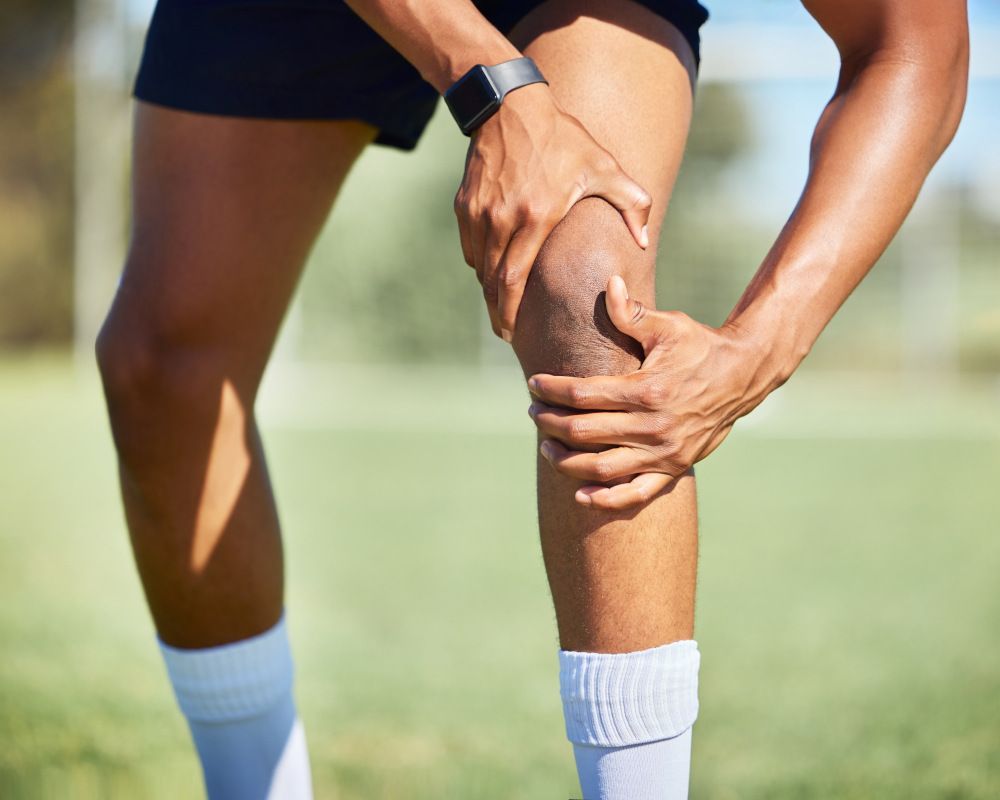 Un deportista cogiéndose la rodilla. Ejercicios para preoperatorios o postoperatorios.